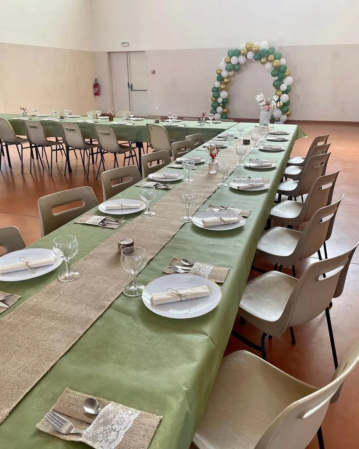 Longue table dressée en vert sauge et toile de jute