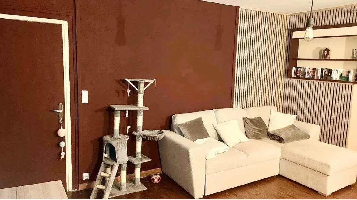 Salon après : mur terracotta, canapé blanc et claustra en bois
