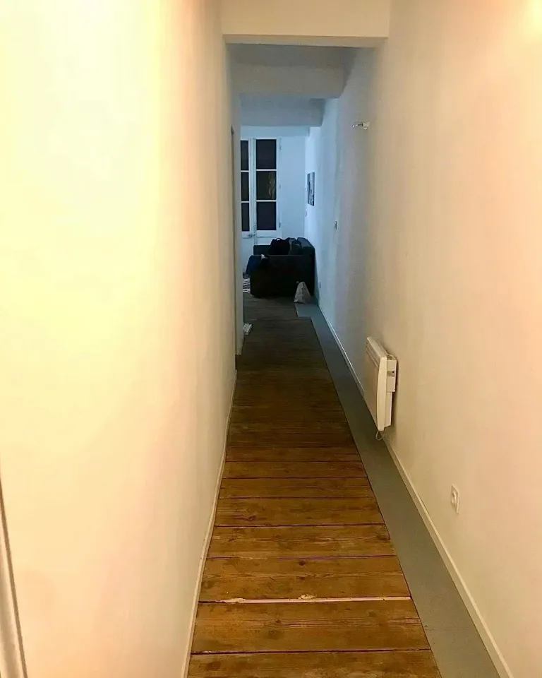Couloir avant : murs blancs et parquet nu